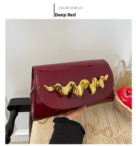 Detail der dunkelroten Abendtasche aus Lackleder mit goldener Metallschnalle
