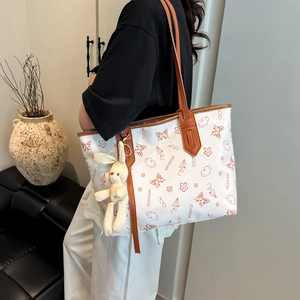 White tote bag with butterfly prints and rabbit charm worn by model for daily commute