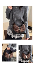 Detail of leopard print handbag featuring black leather trim and gold metal buckle accents