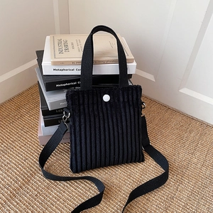 Black corduroy mini tote bag with white button closure and adjustable strap for women