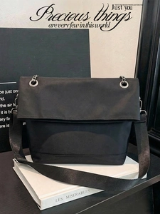 Detail of black nylon tote bag with silver eyelets and wide shoulder strap for daily use