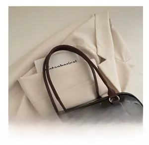 Close-up of deep brown glossy PU leather bowling bag with bow and wooden beads decor