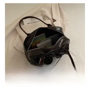 Interior capacity of deep brown bowling bag showing spacious storage for books and wallet