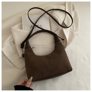 Detail view of a vintage dark brown suede crescent shoulder bag with silver hardware