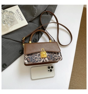 Detail of vintage brown shoulder bag with leopard print pony hair and gold buckle