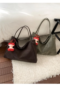 Close-up of retro large tote bags in dark brown and olive green with apple charms