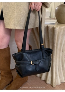 Dettaglio borsa tote retrò in pelle nera con fibbie in metallo dorato e finitura opaca