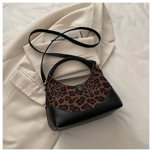 Détail du tissu à imprimé léopard et couture en cuir noir sur un sac seau rétro