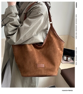 Detail of large brown suede hobo bag featuring premium leather straps and vintage texture
