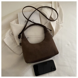 Top view of brown suede half-moon crossbody bag with top handle and leather strap