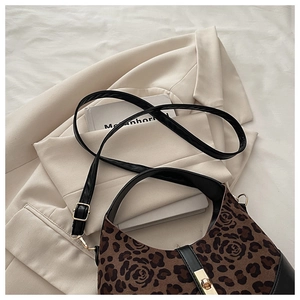Détail du sac à main en daim à imprimé léopard et rose avec des accessoires dorés