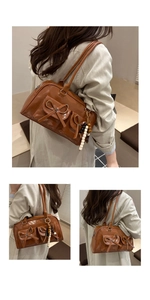 Detail of caramel glossy shoulder bag featuring bow pockets and colorful bead charm