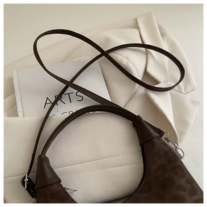 Detail of dark chocolate leopard embossed crossbody bag with silver metal hooks