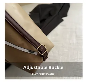 Détail de la boucle dorée réglable et des coutures en cuir sur la bandoulière du sac