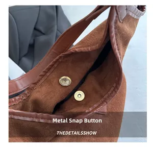 Close-up of brown suede bag showing high-quality magnetic buckle and textured lining