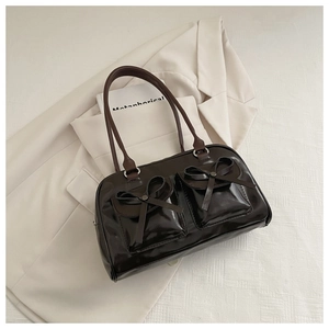 Close-up of vintage coffee brown shoulder bag with bow pockets and metallic rivets