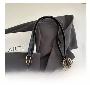 Detail of black tote bag featuring moon-star texture and golden chain leather handles