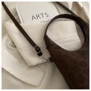 Detail of vintage leopard print crescent bag showing suede texture and leather strap