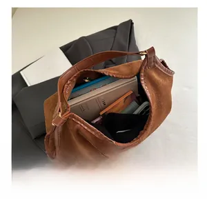 Top-down view of spacious brown suede tote bag showing large capacity for books and tablet