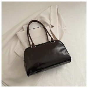 Detail of dark brown leather underarm bag with silver metal ring buckle and dual straps