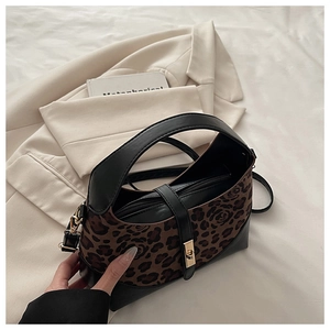 Détail du sac léopard avec motifs de roses et fermoir doré sur blazer beige chic