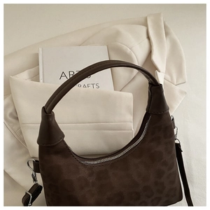 Close-up of leopard print shoulder bag with suede texture and half-moon silhouette