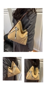 Detail view of khaki tote bag with black and white bow ribbon and diagonal zipper detail