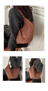 Detail of a large brown suede tote bag featuring slim leather straps and retro style