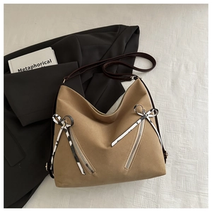 Detail of khaki tote bag with animal print bow ribbons and brown shoulder straps