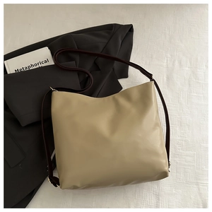 Flat lay of beige tote bag with brown straps on blazer background for business style