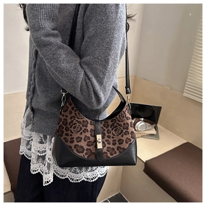 Detail of hobo shoulder bag with leopard print, floral patterns and golden twist lock