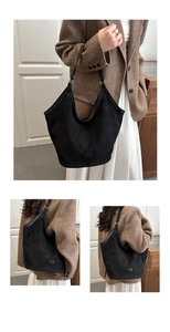 Macro detail of high-quality black suede tote bag showing texture and leather strap