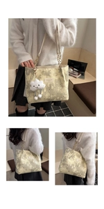 Detail of canvas tote bag with celestial print, chain strap and cloud plush pendant