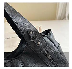 Detailed view of the stitching and metal ring hardware on a black retro tote bag