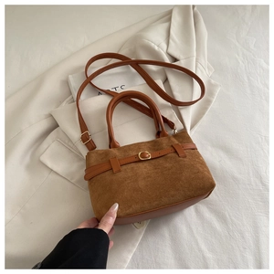 Détail du sac bandoulière en daim marron avec boucle en métal et sangle réglable