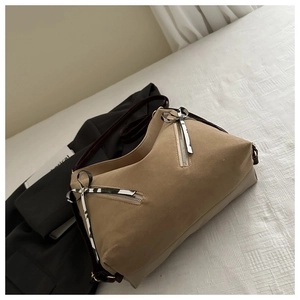 Détail du sac cabas kaki avec fermetures éclair diagonales et ruban décoratif chic