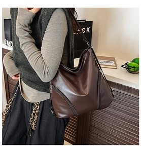 Détail d'un grand sac cabas marron en similicuir avec fermetures éclair en métal chic