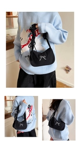 Détail du sac hobo en velours noir avec broderie nœud blanc et bandoulière plissée