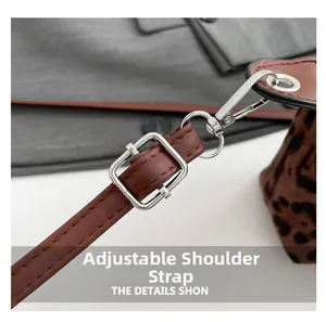 Detail of adjustable leather shoulder strap with silver buckle on leopard print bag