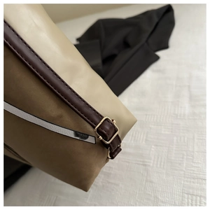 Détail de la boucle en métal doré réglable sur la bandoulière en cuir beige et argent