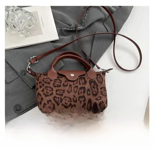 Close-up of leopard print shoulder bag with brown leather handles and silver hardware detail