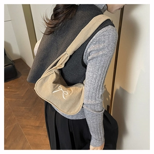 Détail du sac à bandoulière en velours côtelé kaki clair avec broderie nœud blanc