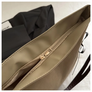Détail du sac cabas kaki avec fermeture éclair en métal doré et finition en cuir lisse