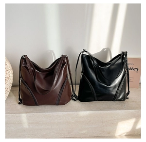 Détail de sacs fourre-tout minimalistes en cuir marron et noir avec fermetures éclair