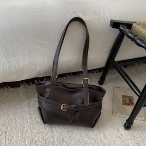 Minimalist chocolate leather tote bag for women shown on a cozy cream-colored rug