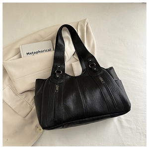 Detailed macro view of black lychee grain leather handbag with silver zip accents