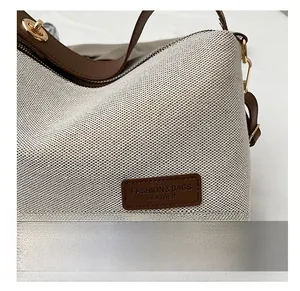 Close-up of woven fabric texture with brown leather trim and golden zipper on shoulder bag