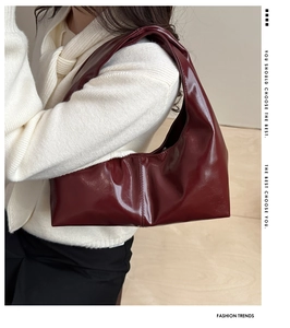Detail of burgundy glossy leather tote bag shown on model for a retro vintage look