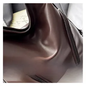 Vue détaillée du sac en cuir marron foncé avec coutures fines et fermeture éclair fluide