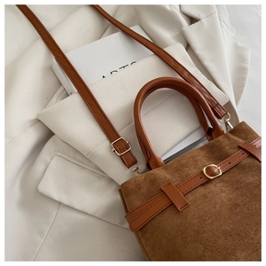 Close-up of caramel matte suede bucket bag with gold hardware and leather strap